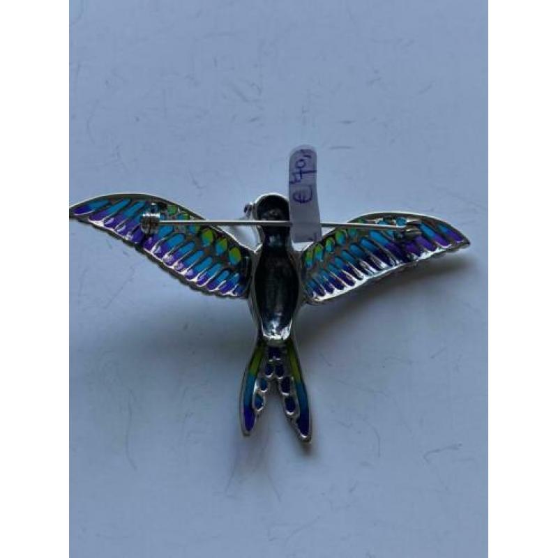Zilveren broche van vliegende vogel.