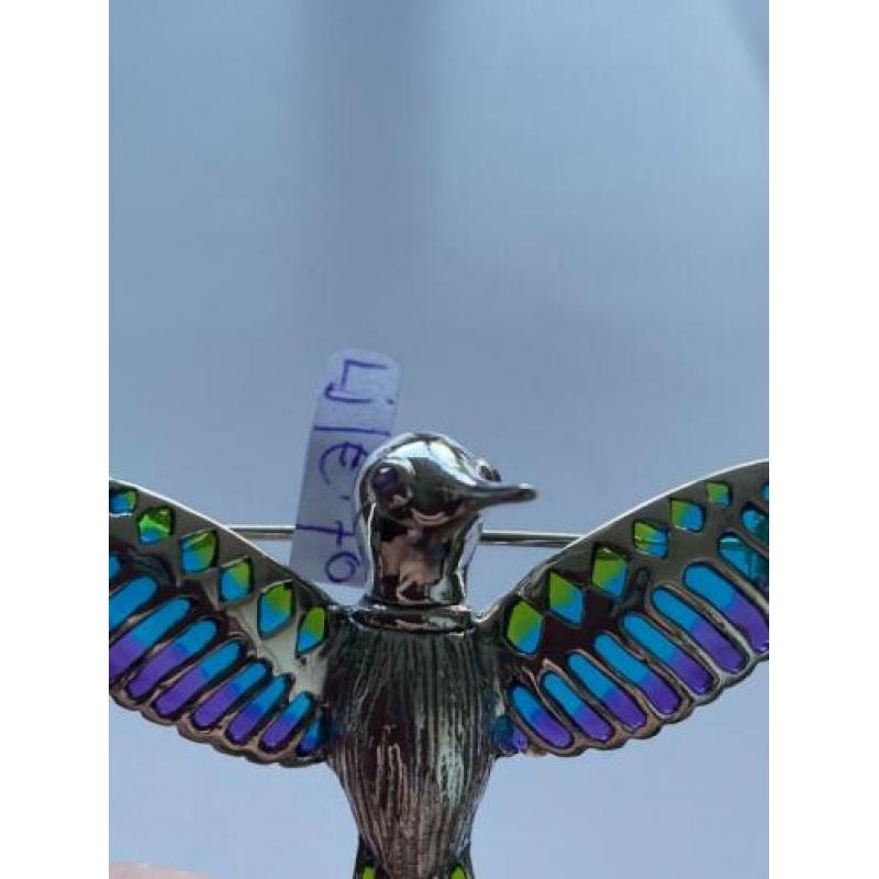 Zilveren broche van vliegende vogel.
